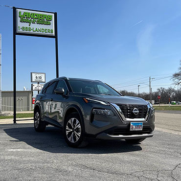 Nissan Suv after collision repair parked in front of Lander's sign