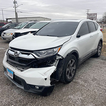 White Honda SUV before collision repair with damaged front bumper