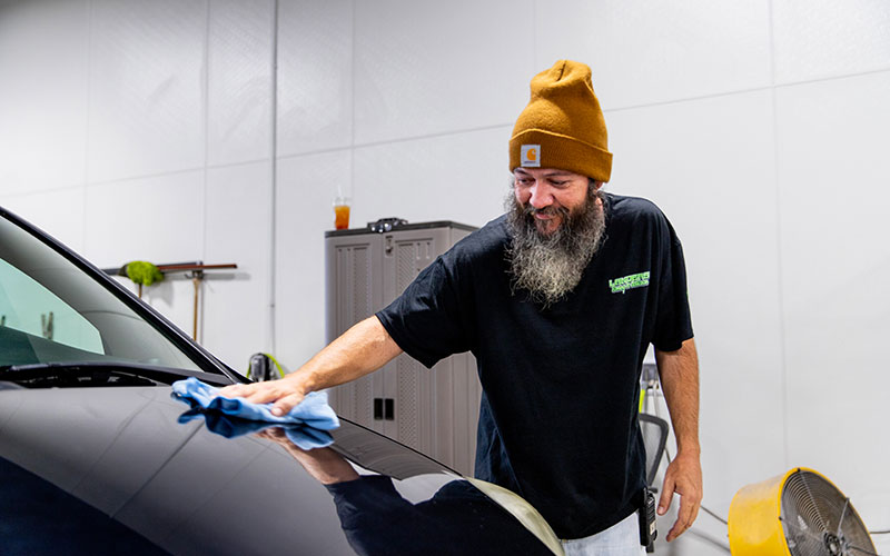 Lander's automotive working cleaning vehicle with smile on face