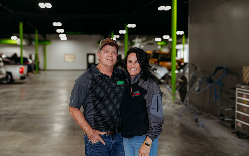 Portrait of Lander's owners posing inside of auto shop