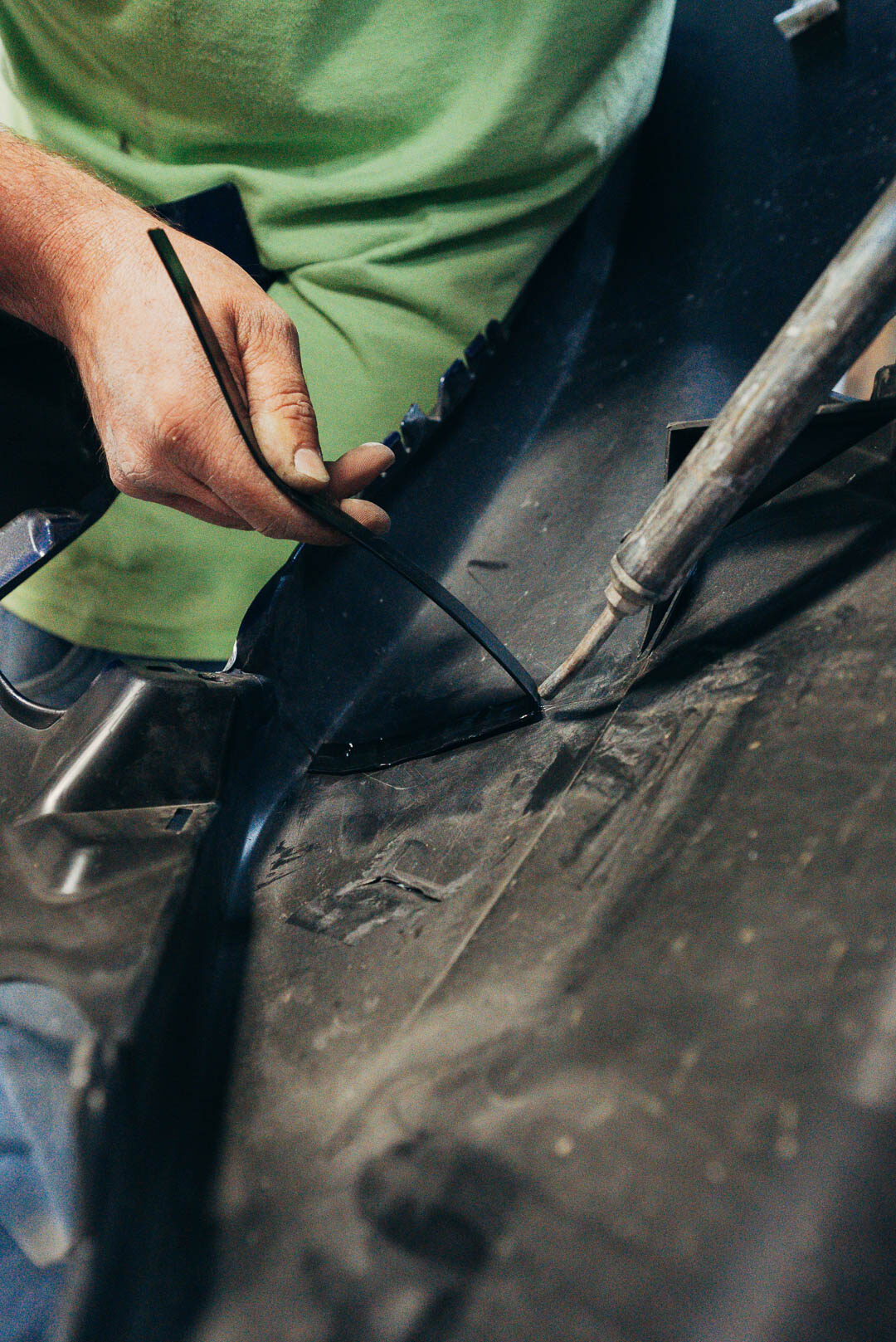 Close-up Lander's automotive mechanic working on vehicle fender