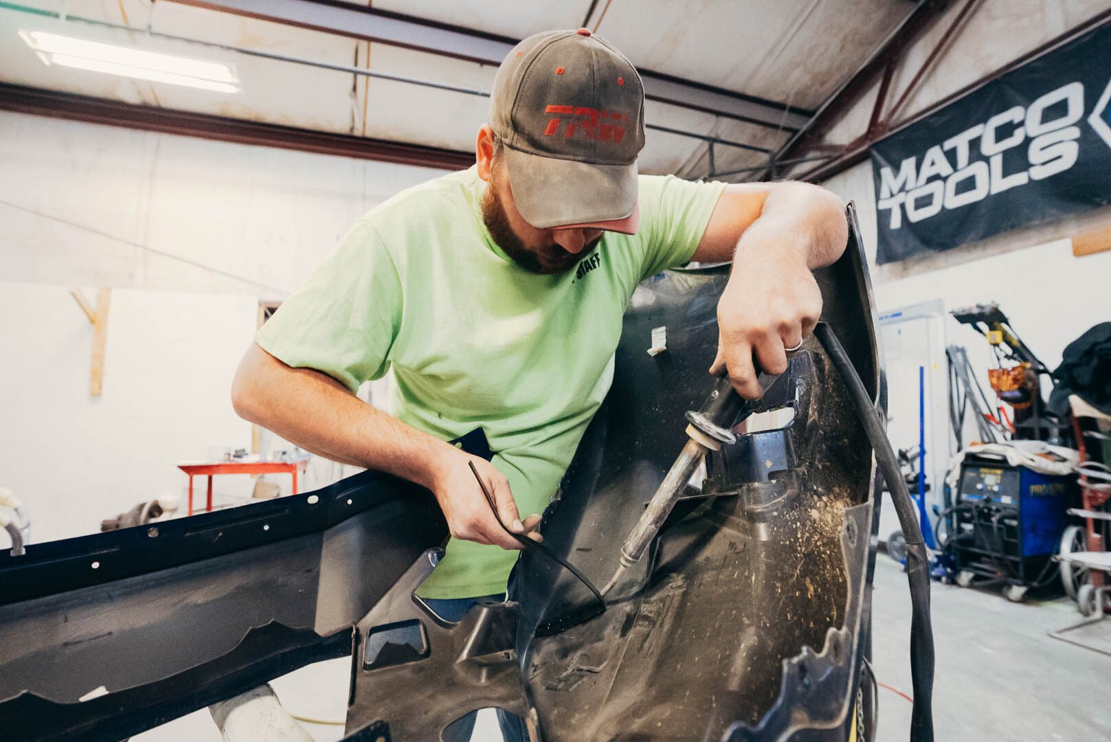 Close-up Lander's automotive mechanic working on vehicle fender
