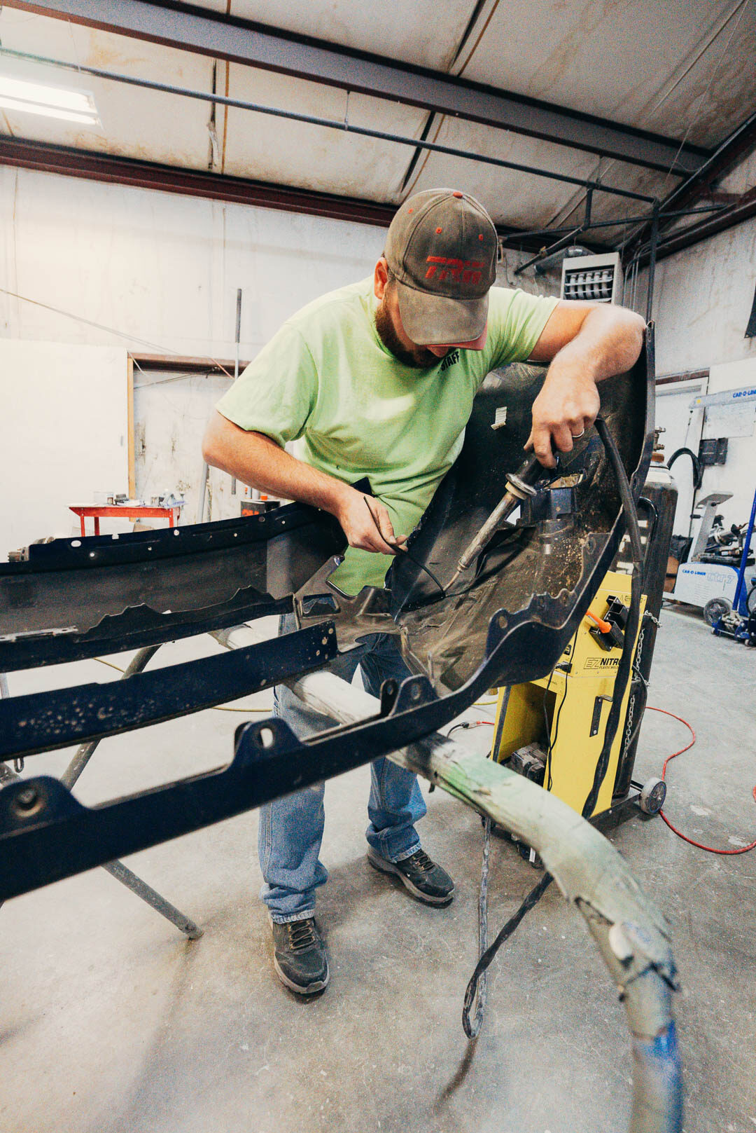 Lander's automotive mechanic working on vehicle fender