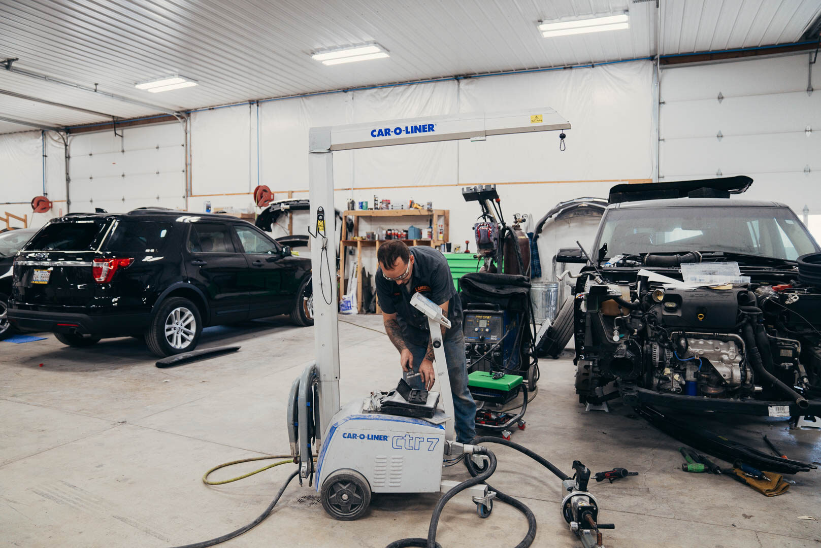 Lander's auto employee using a Car-o-liner welding machine