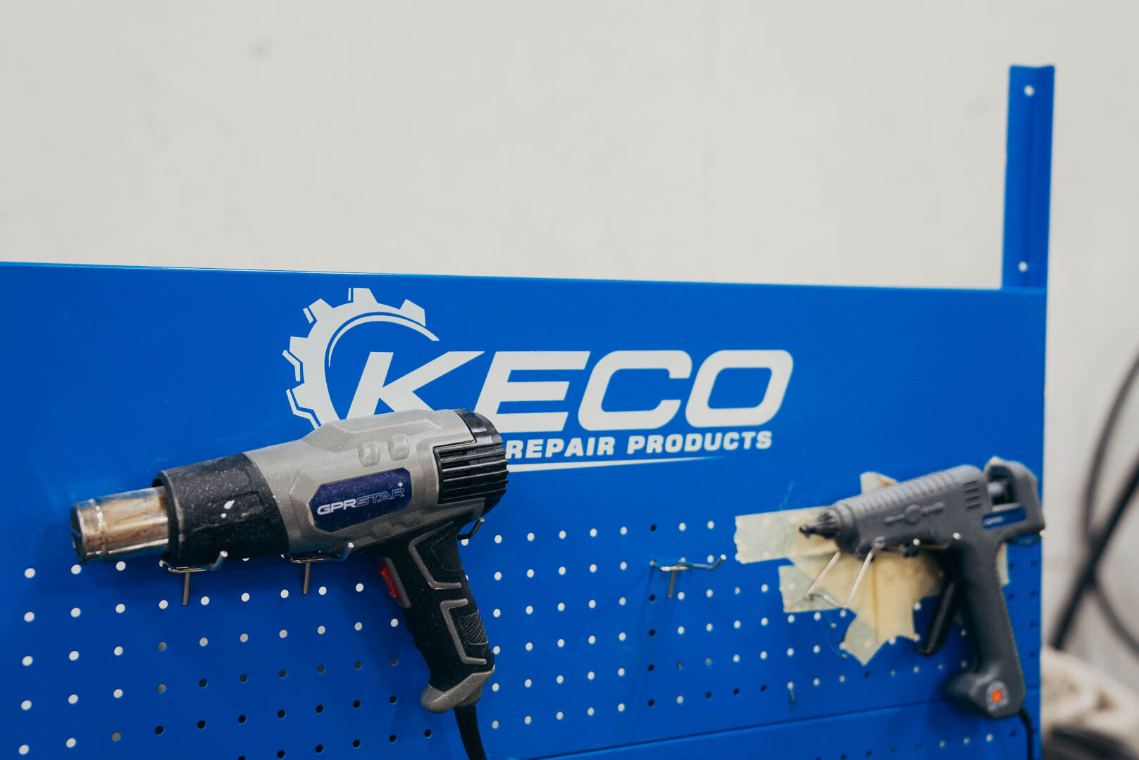 Close-up of blue Keco Auto Repair Products rack with auto gun tools
