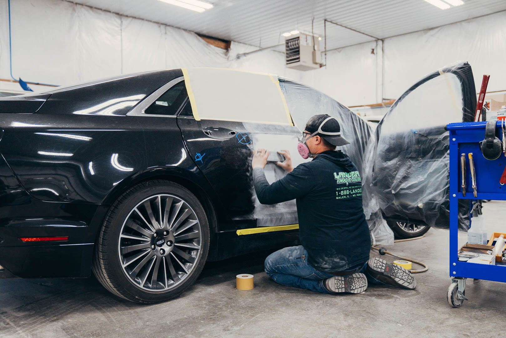 Close-up of Lander's employee preparing black car for painting