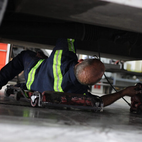 Landers heavy-duty truck mechanic working underneath vehicle