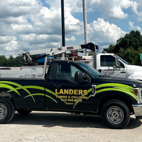 Landers towing trucks parked next to highway