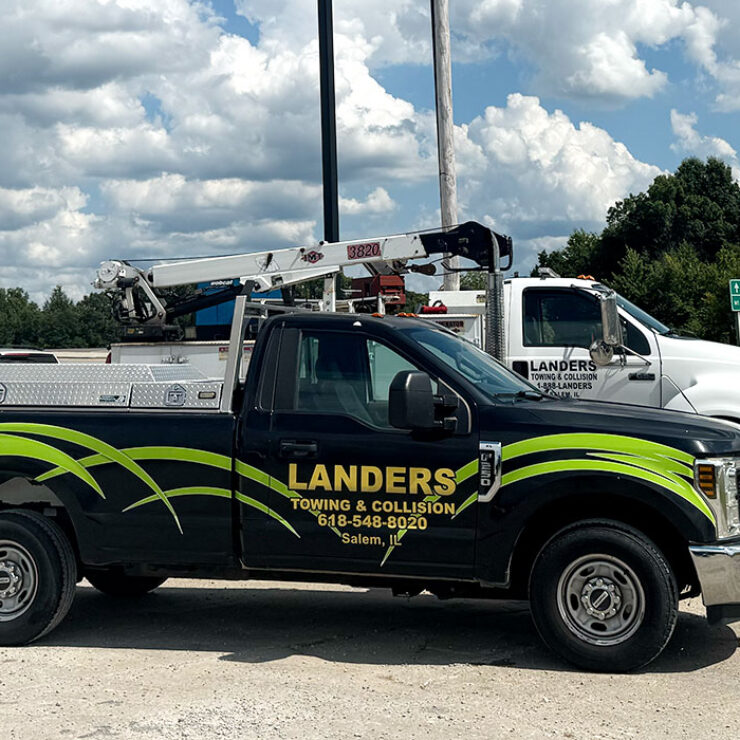 Landers towing trucks parked next to highway